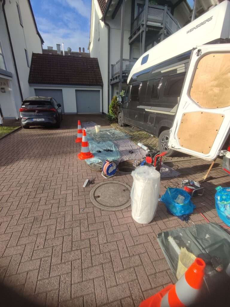 Einsatzfahrzeug und Sanierungstechnik bei der Kurzlinersanierung einer Grundleitung.