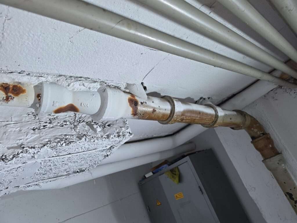 Altersbedingt beschädigtes Gussrohr im Keller eines Mehrfamilienhauses vor der Sanierung in Lörrach