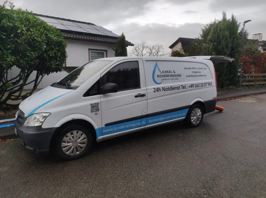 Servicefahrzeug mit Anhänger vor einem Wohnhaus