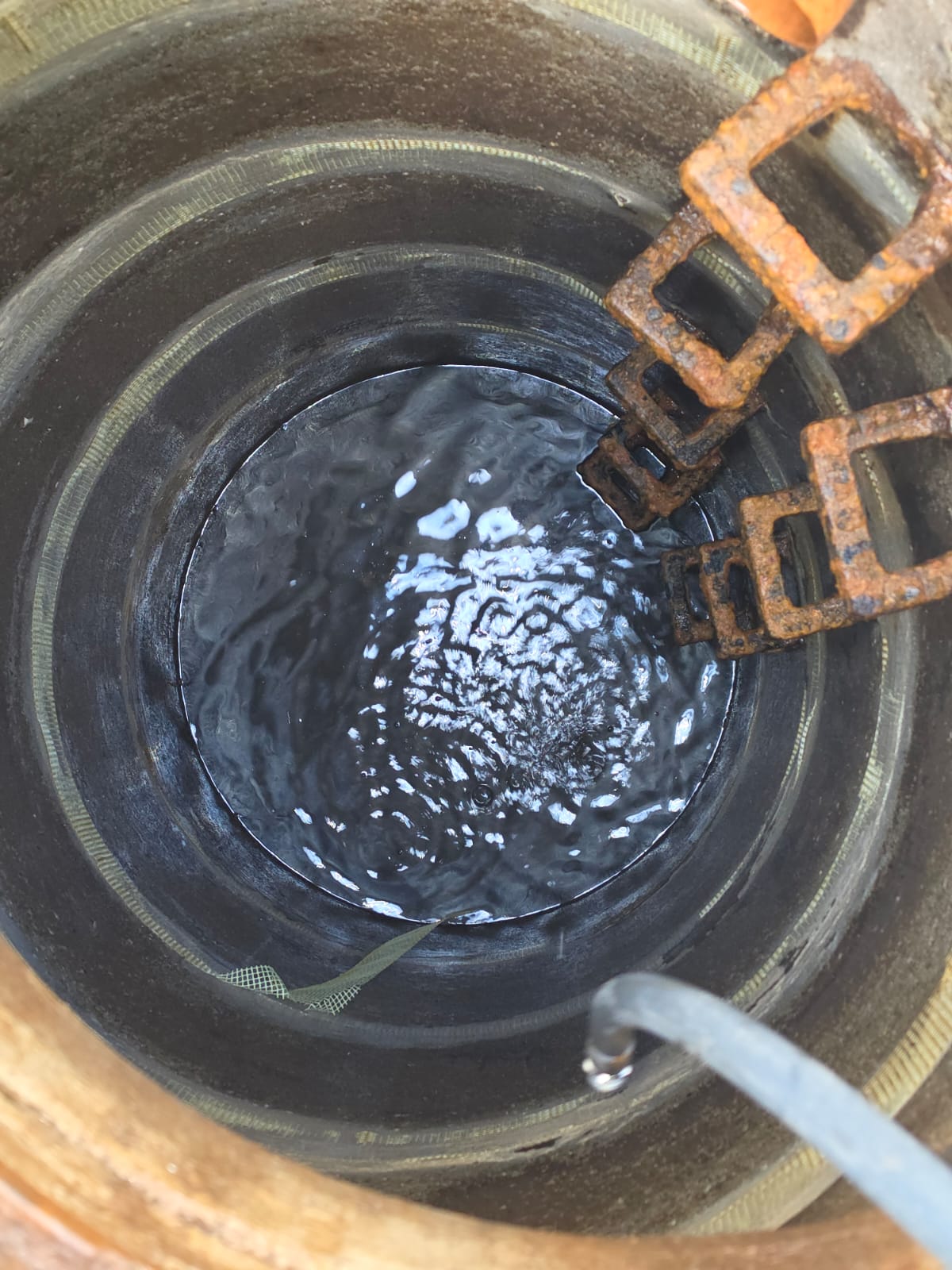 Innenansicht der Zisterne mit Wasser am Boden und sichtbaren Ringfugen